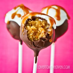 two chocolate covered cake pops with caramel drizzle on top and white icing