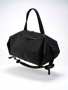 The SANNA is the ideal travel companion for those who are planning a multi-day trip and require both adequate storage space and comfort. Taking on the form of a duffle bag, the SANNA can be carried in a number of ways, either using the shoulder strap or carry handles. Black buckles on the exterior are used to hold the shoulder straps in place when they are not in use. Modern Black Shoulder Bag For Weekend Trips, Functional Black Satchel For Trip, Versatile Large Capacity Duffle Bag For Daily Use, Nylon Duffle Bag With Adjustable Strap And Double Handle, Modern Nylon Shoulder Bag For Travel, Nylon Travel Shoulder Bag With Adjustable Strap, Nylon Duffle Bag With Adjustable Strap For On-the-go, Nylon Shoulder Travel Bag With Adjustable Strap, Nylon Tote Bags For Trips