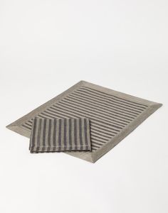 two gray and black striped rugs sitting on top of a white floor next to each other