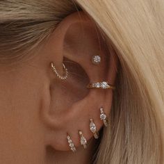 a woman with blonde hair wearing three different ear piercings