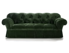 a green velvet couch with buttons on the back and arms, in front of a white background