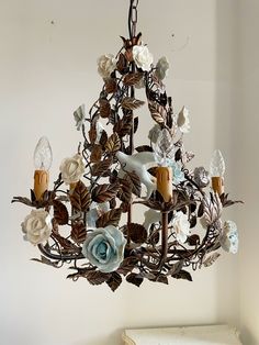 a chandelier with flowers and leaves hanging from it