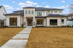 a large white house sitting on top of a lush green field