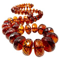 Superb, rare natural translucent faceted Baltic amber necklace of impressive size, gem quality and color reminiscent of fine rich cognac. This necklace has been tested for natural amber and has a high degree of electrical attraction. The reddish orange, vermillion color is scarcely seen in natural amber necklaces of this scale. Amber has long been associated with the power of attraction and excellent communication, as is the color red- making this necklace doubly desirable. 38.5 inches (97.8cm) Luxury Orange Gemstone Beads Jewelry, Luxury Orange Gemstone Beaded Necklaces, Unique Luxury Orange Necklaces, Luxury Citrine Amber Necklace, Luxury Amber Natural Stones, Luxury Polished Amber Beads, Luxury Amber Oval Beads Jewelry, Luxury Gold Plated Amber Jewelry, Luxury Amber Bohemian Beads