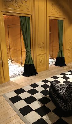 a black and white checkered floor with green curtains