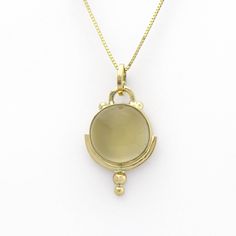 This lovely golden moonstone amulet is SASA's trademarked Art Deco style in a handmade 14K yellow gold setting. Little solid 'bubbles' of gold on the tip add sparkle when light falls upon them. According to Hindu mythology, moonstone is made of solidified moonbeams. Many other cultures also associate this gem with moonlight, and it's easy to see why. Its internal structure scatters the light that strikes it, creating a phenomenon known as adularescence. The visual effect is reminiscent of the fu Chalcedony Cabochon Yellow Gold Jewelry, Yellow Gold Chalcedony Jewelry With Cabochon, Formal Yellow Gold Chalcedony Jewelry, Yellow Gold Moonstone Jewelry, Vintage Gold Moonstone Jewelry, Unique Yellow Gold Moonstone Jewelry, Gold Moonstone Round Stone Jewelry, Gold Moonstone Jewelry With Bezel Setting, Gold Moonstone Jewelry With Round Stone