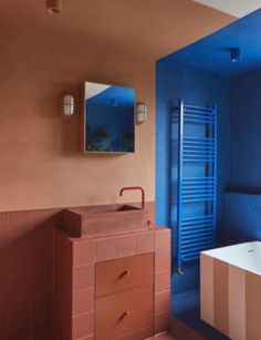 a bathroom with blue walls and pink tiles