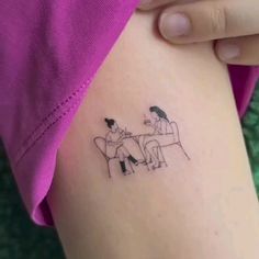 two people sitting at a table tattoo on the back of a woman's thigh