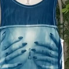 a woman's blue tank top with her hands on the chest and nails painted on it