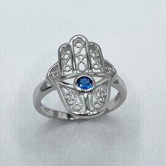 *  Sterling Silver Hamsa Tiny Blue Sapphire CZ Ring, Hand of God Ring, Religious Ring, Hamsa Promise Ring, Silver Ring, Statement Ring, Love Ring, Boho Ring, Eye Ring, 925 Stamped *  Hamsa is primarily used to protect its owner from the Ayin Ha'ra also known as The Evil Eye Protective talisman that brings good fortune, health and happiness *  Perfect gift idea for any occasion: birthday, anniversary, engagement, graduation, bridesmaid, Mother's Day, Valentine's Day, Christmas, promise. *  Your p Blue Round Jewelry For Promise, Handmade Blue Jewelry For Promise Occasions, Handmade Blue Jewelry For Promise, Symbolic Blue Ring As Gift, Symbolic Blue Ring For Anniversary, Handmade Blue Promise Ring, Blue Open Ring, Handmade Blue Wedding Rings, Adjustable Blue Birthstone Ring For Anniversary