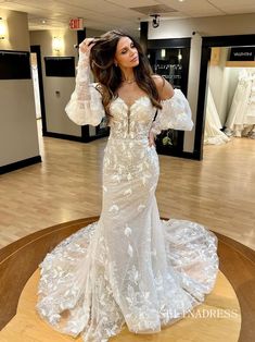 a woman in a wedding dress posing for the camera with her hands on her head