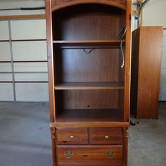 a wooden bookcase with drawers in a garage