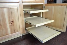 an open cabinet door in a kitchen with wood flooring