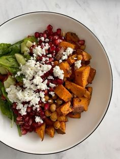 a white bowl filled with vegetables and feta cheese