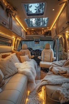 the interior of an rv with couches, pillows and blankets on the bed area