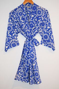 Short cotton kimono robe with stitched placket detail and pockets. Matching Belt, interior ties, and hanging loop at inside neck. 100% lightweight cotton | hand block printed in Jaipur, India Size S/M: 34" length | 15" sleeve length | 53" total body width Size L/XL: 36" length | 16" sleeve length | 62" total body width Machine wash cold water, delicate cycle | Air dry Traditional Indigo Cotton Kimono, Cotton Kimono With Printed Design And Relaxed Fit, Printed Cotton Kimono With Relaxed Fit, Cotton Kimono With Relaxed Fit And Printed Design, Relaxed Fit Cotton Kimono With Floral Print, Cotton Floral Print Robe For Vacation, Blue Bohemian Cotton Robe, Spring Cotton Printed Robe, Summer Indigo Cotton Kimono