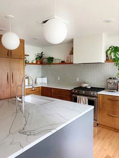 a kitchen with marble counter tops and wooden cabinets, along with an island in the middle