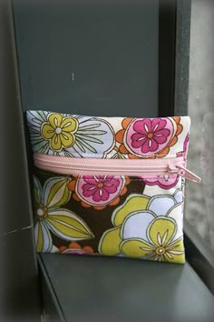 a flowered pouch sitting on top of a window sill next to a window