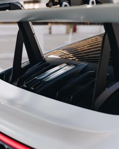 the back end of a white sports car with luggage on it's roof rack