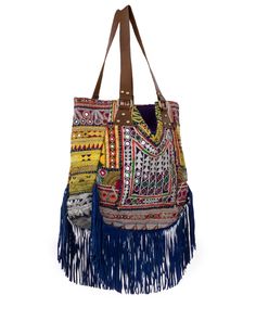 Vintage embroidered pieces salvaged from tunics, blouses, and skirts and masterfully sewn together to make this beautiful one-of-a-kind tote bag. Leather straps fastened with brass details. Fringe details add a fun bohemian touch. Zippered pocket One of a kind Handmade in India Bohemian Shoulder Bucket Bag For Shopping, Bohemian Hobo Bag For Shopping, Bohemian Bucket Bag For Shopping, Bohemian Satchel Bucket Bag For Shopping, Bohemian Bucket Shoulder Bag For Market, Bohemian Shoulder Bucket Bag For Market, Bohemian Hand-stitched Bags, Bohemian Style Shoulder Bag For Market, Bohemian Shoulder Bag For Market