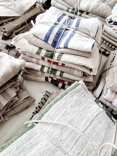 a pile of folded towels sitting on top of a white table next to each other