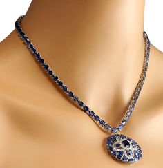 Stamped: 14K White Gold Total Necklace Weight: 29.0 Grams Necklace Length: 17 Inches Necklace Width: N/A Gemstone Weight: Total Natural Center Sapphire Weight is 1.25 Carat (Measures: 8.30x6.20 mm) Color: Blue Gemstone Weight: Total Natural Side Sapphire Weight is 54.45 Carat Color: Blue Diamond Weight: Total Natural Diamond Weight is 1.54 Carat Quantity: 54 Color: F-G, Clarity: VS2-SI1 Face Measures: 34.20x34.30 mm Sku: [702595W] Luxury Sapphire Necklace Hallmarked, Luxury Sapphire Necklace For Formal Occasions, Luxury Sapphire Necklace With Diamond, Dazzling Multi-stone Necklace For Formal Occasions, Formal Round Sapphire Necklaces, Exquisite Diamond Multi-stone Necklaces, Evening Diamond Gemstone Necklace, Diamond Gemstone Necklace For Evening, Formal Round Diamond Necklace With Gemstones