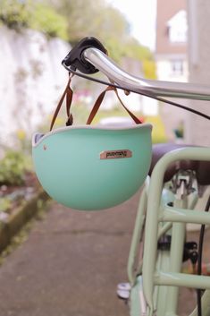 a close up of a bicycle handlebar with a bowl hanging from it's seat