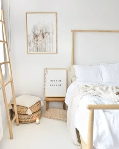 a bedroom with white walls and natural wood furniture, including a wooden ladder that is leaning up against the wall