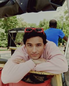 a man with sunglasses on his head sitting in a chair