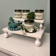 some jars are sitting on a white shelf