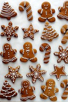 many different types of decorated ginger cookies on a white surface with icing and decorations