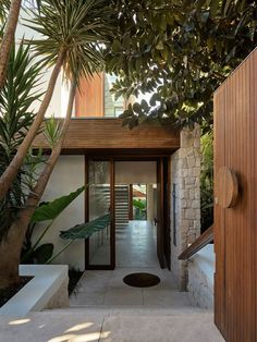 an entrance to a modern home surrounded by trees