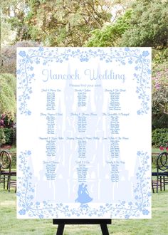 a blue and white wedding seating sign in the middle of a field with chairs around it