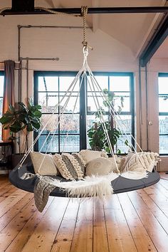 a living room with wood flooring and a hammock hanging from the ceiling