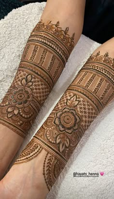 two hands with henna tattoos on them, one is showing it's intricate designs