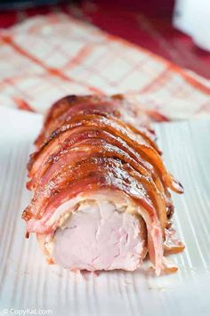 ham wrapped in bacon on a white plate