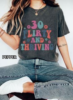 "The model is wearing the color Charcoal.  Celebrate hitting the big 3-0 in style with this cheeky \"30 Flirty & Thriving\" tee! 🎉 The perfect 30th birthday gift for the fabulous woman embracing this milestone year. This retro-inspired tee features distressed text designed in a vintage cursive font. The light pink color adds to the feminine, flirty vibe. 💕 Crafted from 6.0 oz 100% cotton, this tee has a slim feminine fit that flatters curves. Pair with jeans or style it tucked into a skirt for that \"30 and thriving\" look! 👗 Great 30th birthday gift idea for yourself or that fun friend ready to take on their 30s in fearless, flirty fashion. 🥳 This tee is made right here in the USA and machine washable for easy care. It comes in women's sizes S-5XL so all can rock their 30s in style! L Last Day Of School Shirt, Occupational Therapy Shirts, Look Retro, Dance Mom, Color Images, Teacher Tees, Comfort Colors Tee, Last Day Of School, Retro Halloween