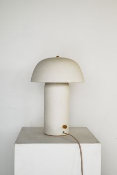 a white lamp sitting on top of a cement block