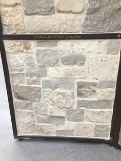 a stone wall with the name storm mountain written on it's side and black metal frame