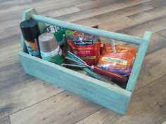 a wooden box filled with lots of food and condiments on top of a hard wood floor