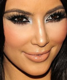 a close up shot of a woman's face with long black hair and makeup