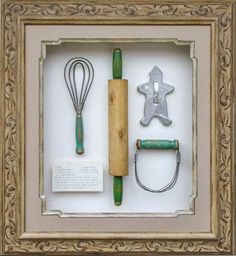 an old framed shadow box with various kitchen utensils and cookie cutters in it