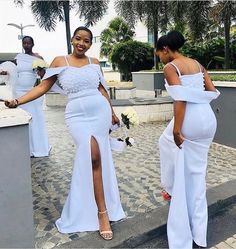 two women in white dresses walking down the street