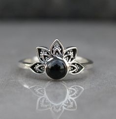 Introducing our exquisite Lotus Flower Ring, a symbol of purity and enlightenment. Crafted with attention to detail, this black onyx mini ring exudes elegance and spirituality. Its minimalist design makes it perfect for everyday wear, while its devotional significance adds a touch of spirituality to any outfit. Made with natural black onyx, this ring is not only a stunning accessory but also a meaningful gift for her. Embrace the beauty and serenity of the lotus flower with this captivating piec Black Oval Spiritual Rings, Black Spiritual Rings With Gemstone, Sterling Silver Spiritual Flower Ring, Spiritual Onyx Ring Jewelry, Adjustable Silver Onyx Ring, Lotus Flower Ring, Meaningful Gifts For Her, Lotus Ring, Black Onyx Ring