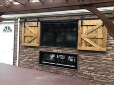 an outdoor fireplace with sliding doors on the side