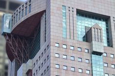 a tall building with many windows and a clock on the top of it's side