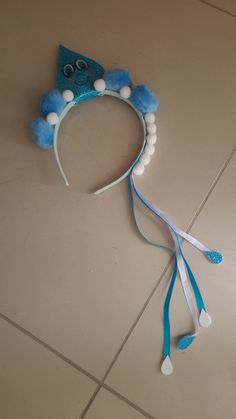 a blue and white cat headband with pom poms