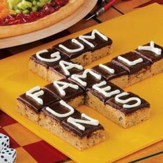 there are four pieces of cake on the table with words spelled out in white letters