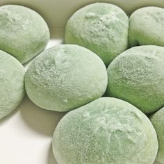 several round green pastries sitting on top of a white surface