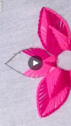 a video demonstrating how to make an origami bird with pink feathers and leaves